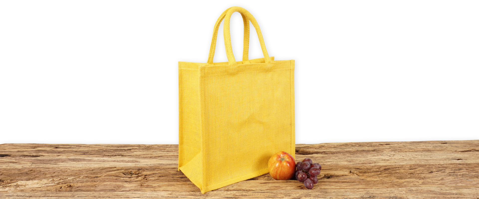Einkaufstasche aus Jute zum Bedrucken für Gewerbekunden in gelb mit Seiten-Bodenfalte, klein und mit kurzen Tragegriffen auf Holz.