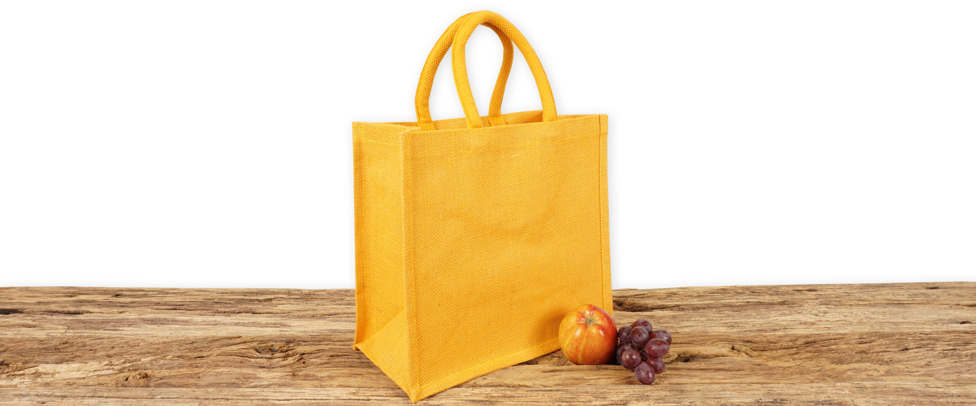 Einkaufstasche aus Jute farbig in Orange mit Seiten-Bodenfalte, klein, bedruckbar und mit kurzen, runden Tragegriffen auf Holz.