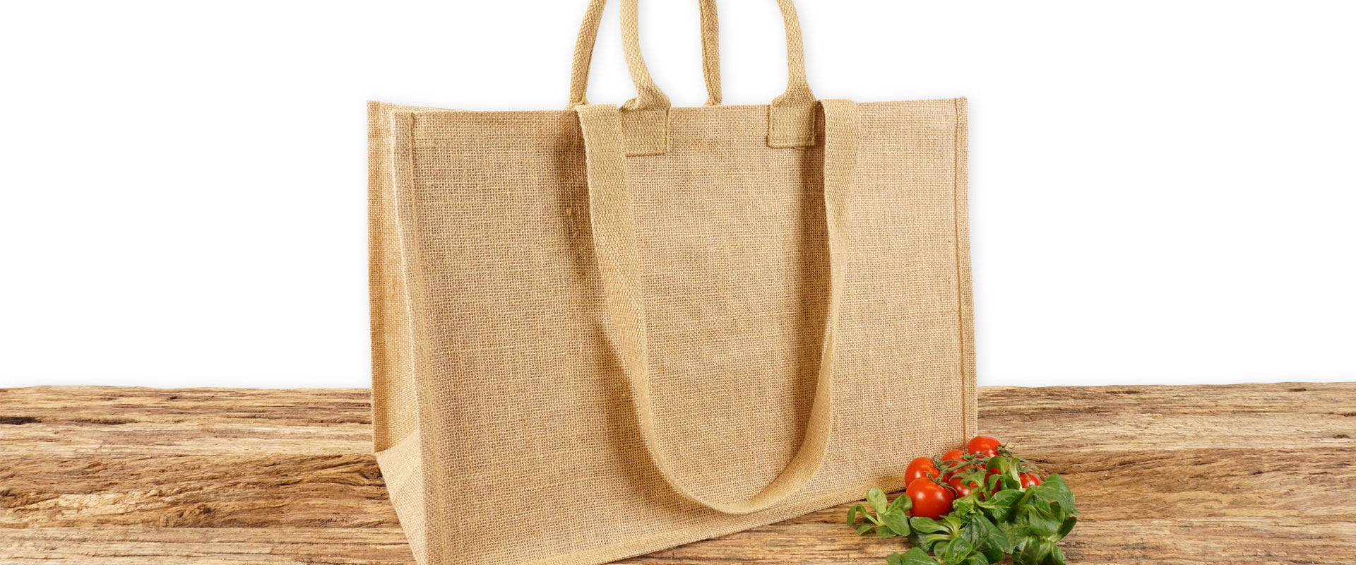 Einkaufstasche aus Jute naturfarben mit Seiten-Bodenfalte, groß, bedruckbar und mit kurzen runden und langen Tragegriffen auf Holz.