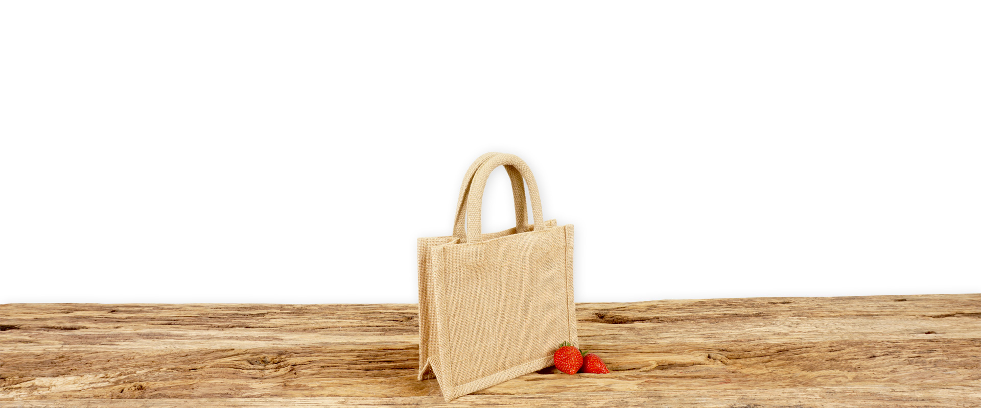 Tasche aus Jute naturfarben mit Seiten-Bodenfalte, extra klein, bedruckbar und mit kurzen runden Tragegriffen auf Holz.